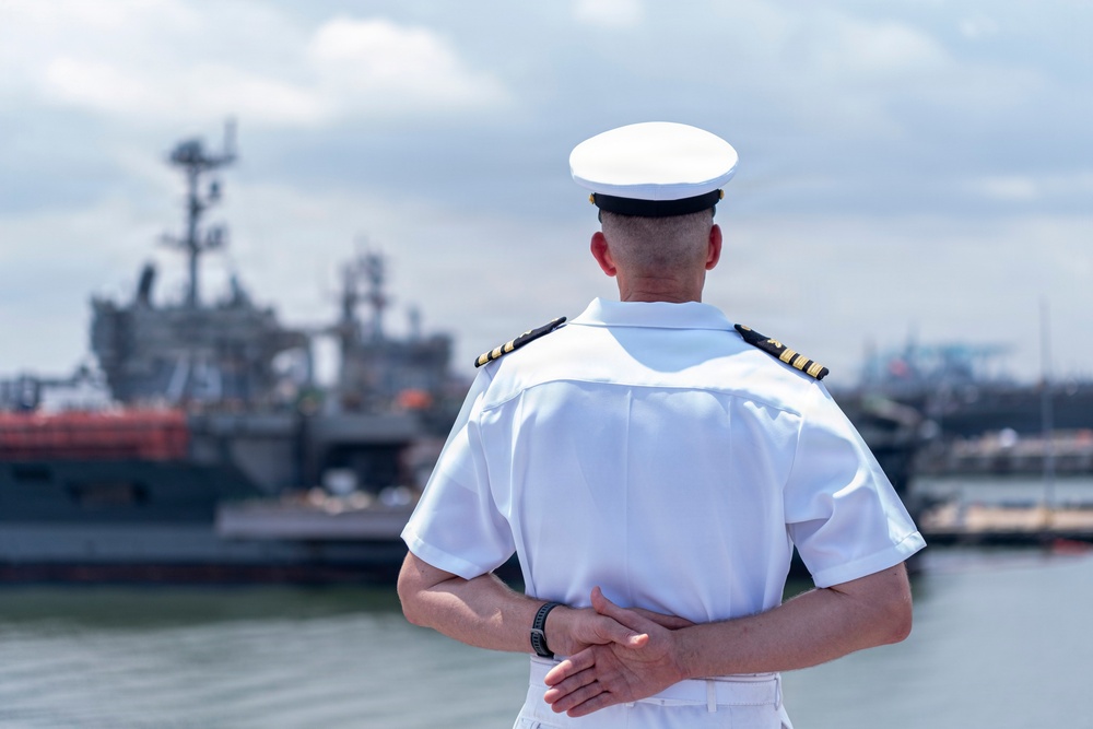 A U.S. Navy Sailor aboard USS Nimitz as it arrives at Naval Station Norfolk